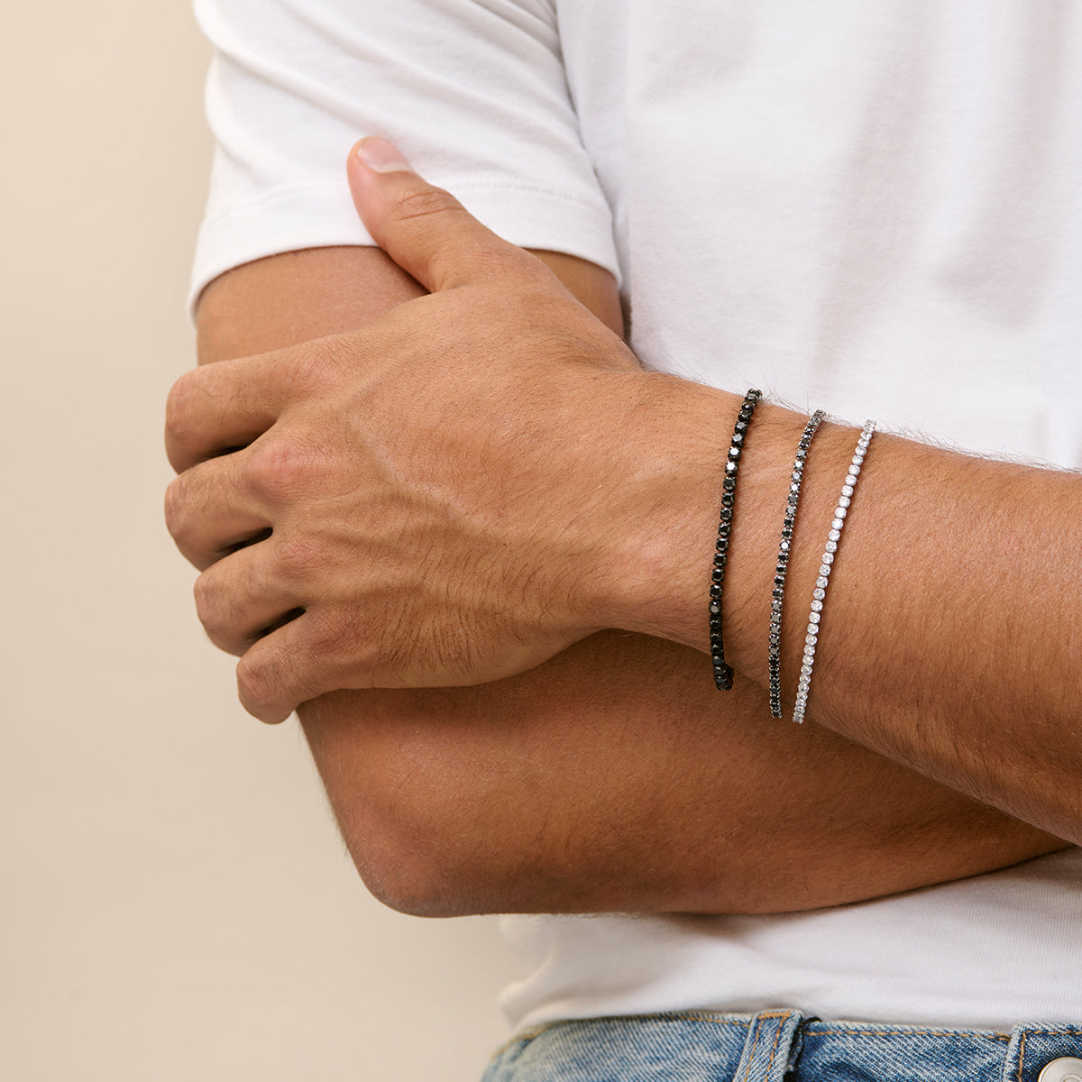 Fashionable men's wrist wearing elegant bracelets.