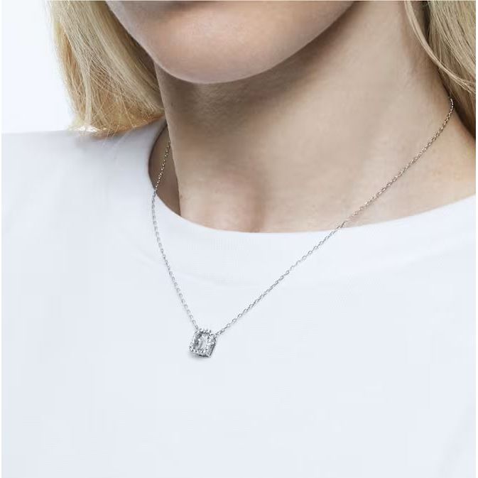 Elegant silver necklace with a square pendant on a woman wearing a white shirt.