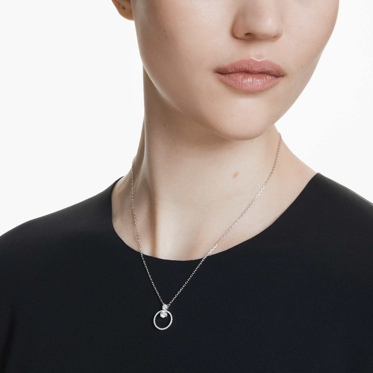 Elegant lady wearing a silver necklace with circular pendant