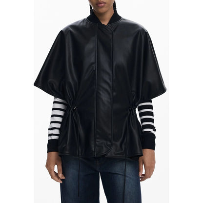 Woman wearing a Desigual Black Polyethylene Women Poncho with stripe sleeves, featuring a drawstring waist and embossed design.