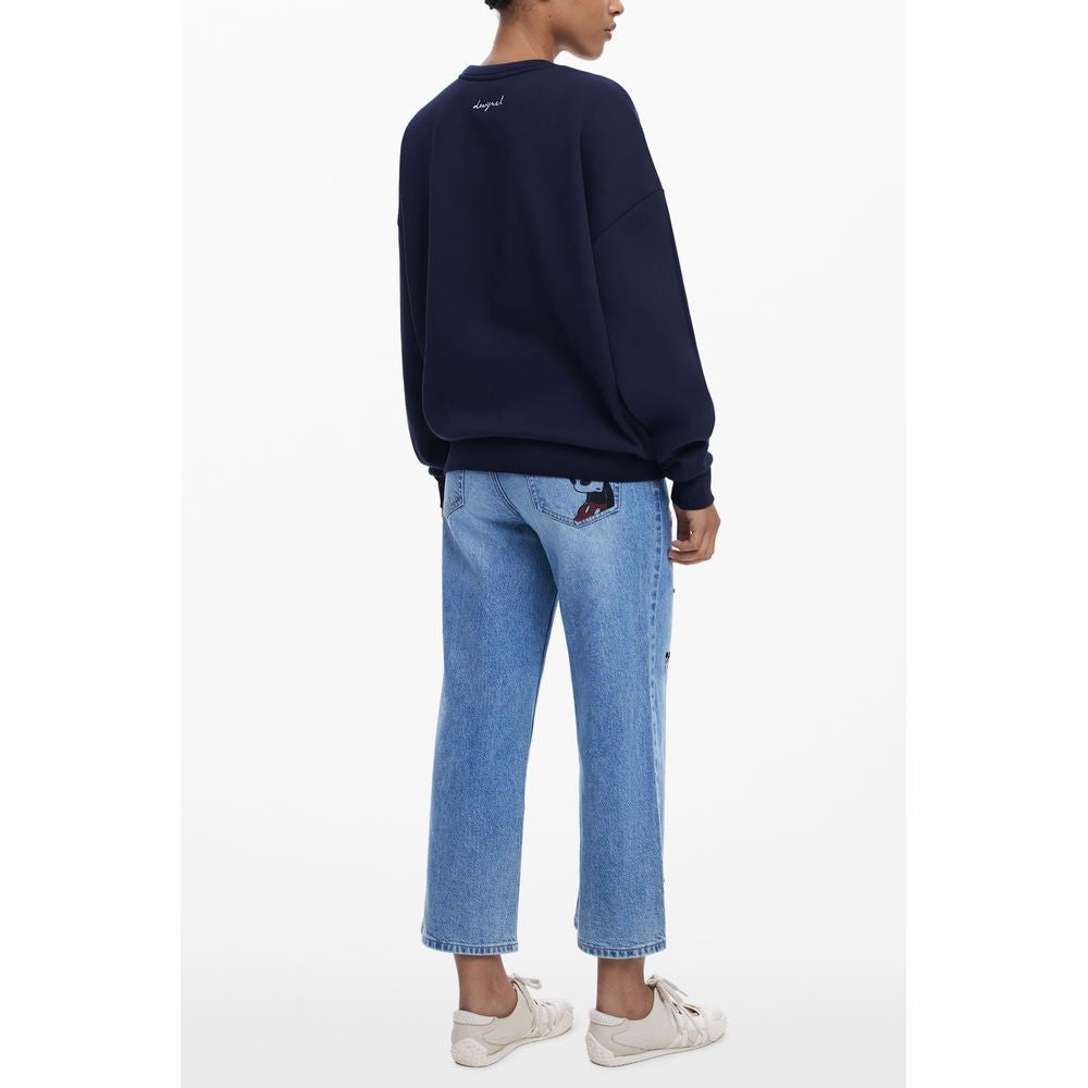 Rear view of model wearing Desigual Blue Cotton Women Sweater with Mickey print, paired with jeans and sneakers, showcasing stylish back design.