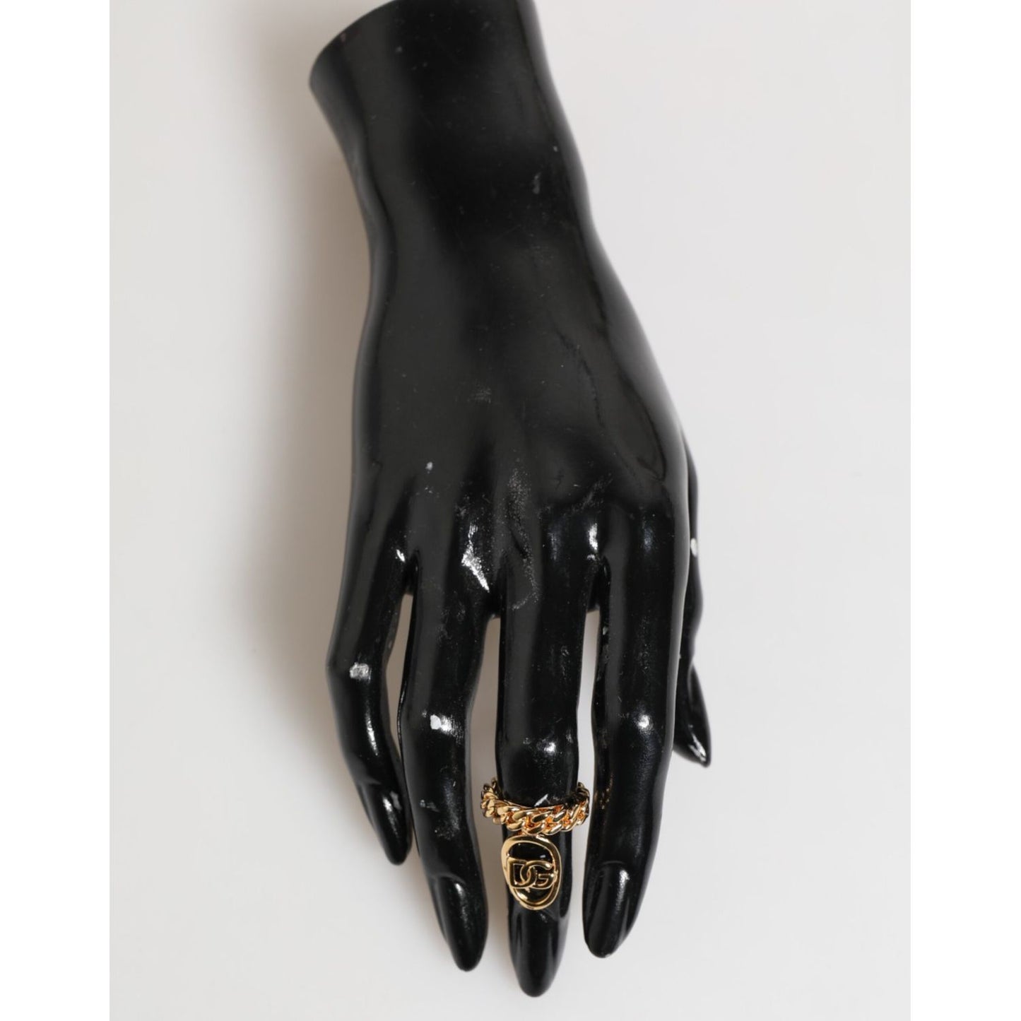 Dolce & Gabbana Gold Tone Brass Oval DG Logo Chain Adjustable Ring displayed on a mannequin hand.