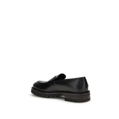 Ferragamo Black Rubber Slip-On Loafers with rugged lug sole and slightly rounded toe, showcasing elegance and modern allure.