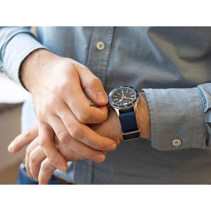 Person wearing NAUTICA Mod. NAPABS904 watch with blue strap, quartz analog movement, 43mm case, mineral dial, water resistant up to 5 ATM.