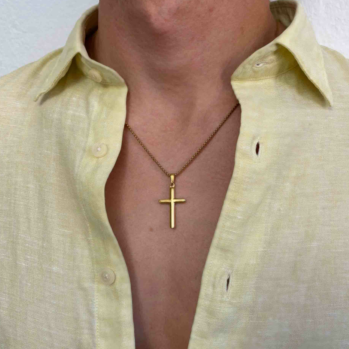Man wearing gold cross necklace on open collar shirt