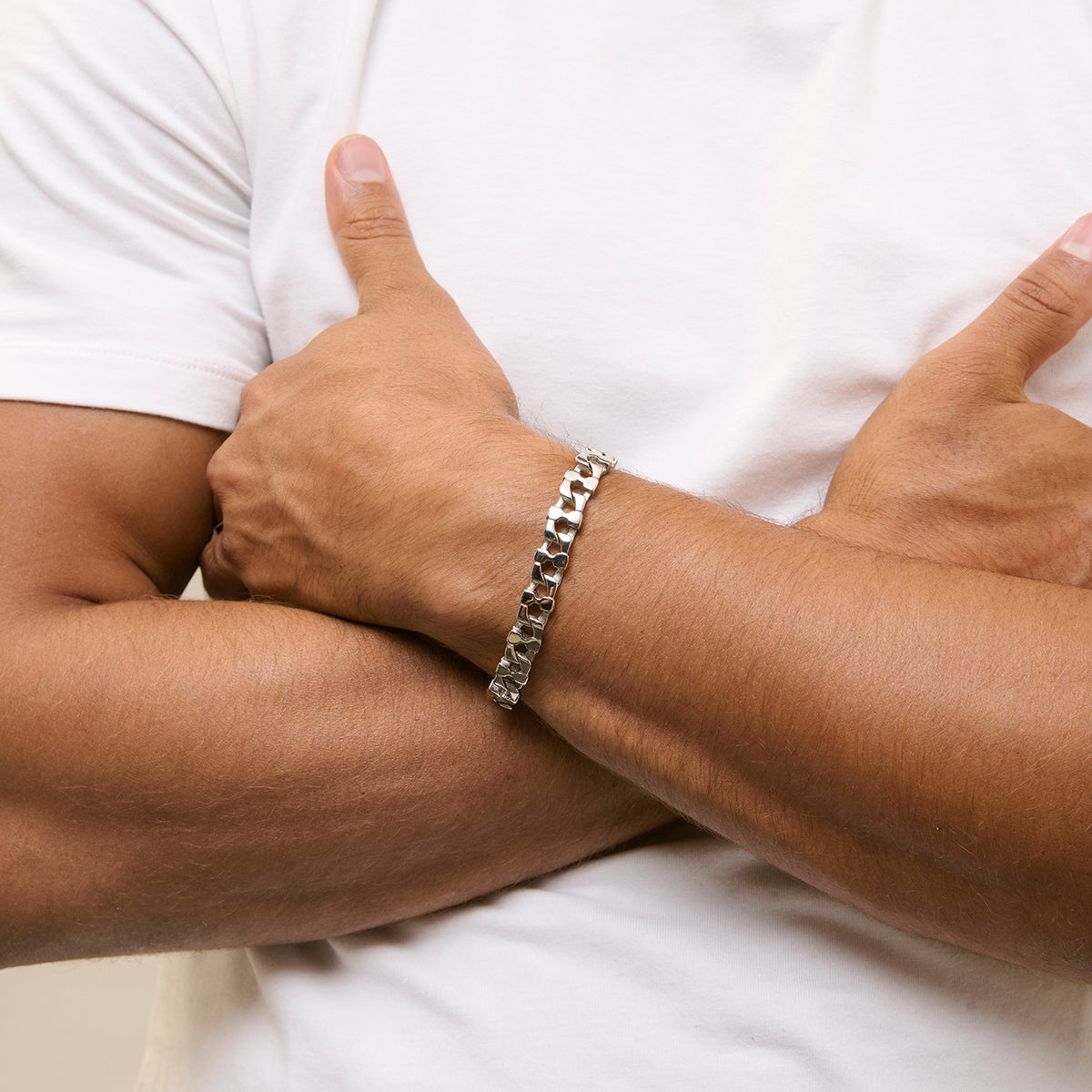 Man wearing silver bracelet RADIANT JEWELS JEWELRY Mod. RH000328, showcasing elegant design on crossed arms.