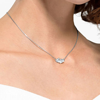 Woman wearing elegant SWAROVSKI Mod. 5517117 necklace highlighting the crystal pendant.