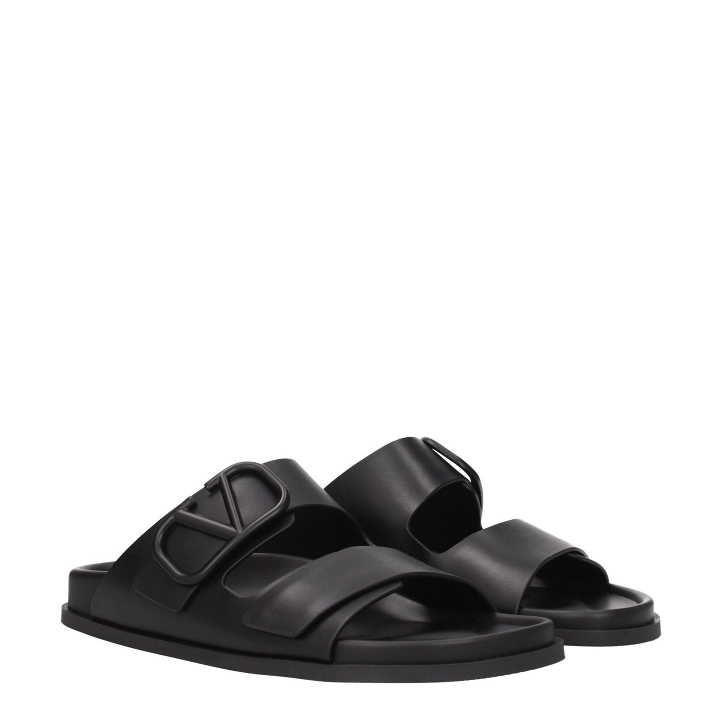 Valentino Garavani Black Leather Slippers with open toe and front logo detail, featuring low flat heel and rubber sole.