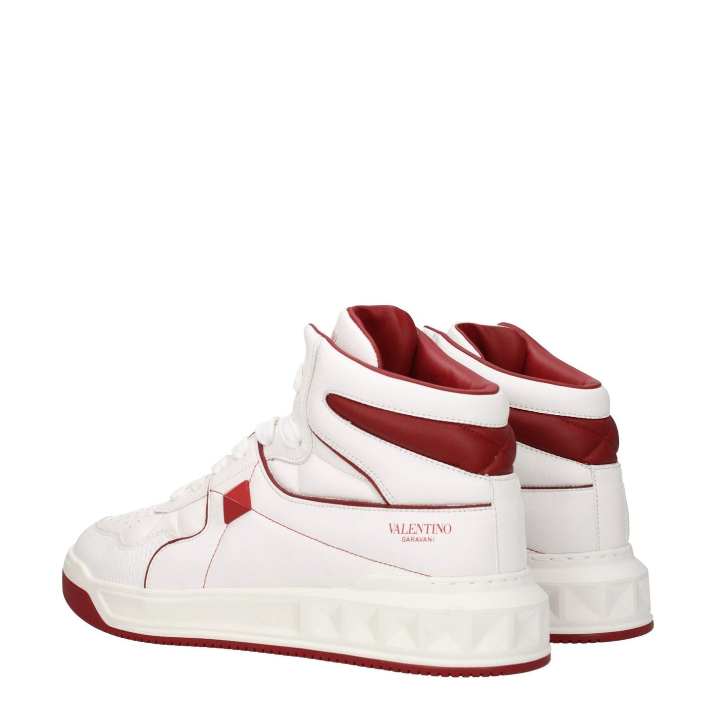 Valentino Garavani White Leather High Top Sneakers with studs and logos in white and red, featuring lace-up closure and rubber sole.